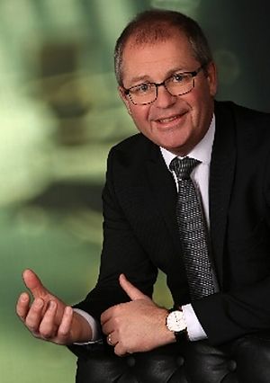 Porträt des Bürgermeisters. Er hat kurze Haare, trägt eine Brille und einen schwarzen Anzug mit Krawatte.