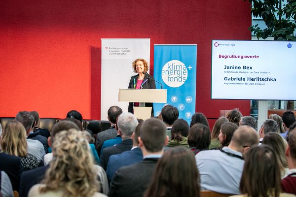 Sprecherin auf dem Podium und Publikum im Saal