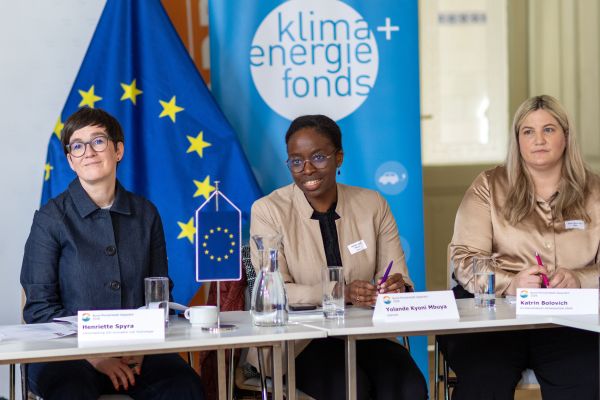 Drei Frauen sitzen an einem Tisch und sprechen mit den Vertreter:innen der Städte