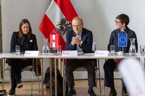 Personen sitzen um einen Tisch und reden miteinander