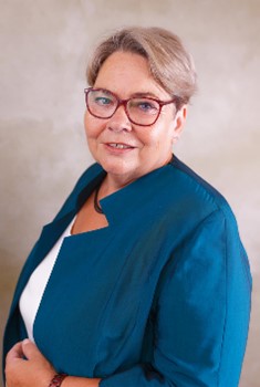 Portrait der Bürgermeisterin. Sie hat kürzeres blondes Haar, trägt Brillen und ein blaues Sakko.